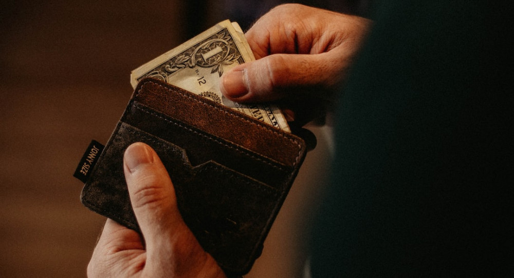 Man pulling cash out of wallet.