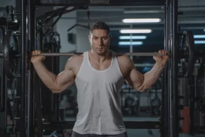 man with big muscles working out inside squat cage.