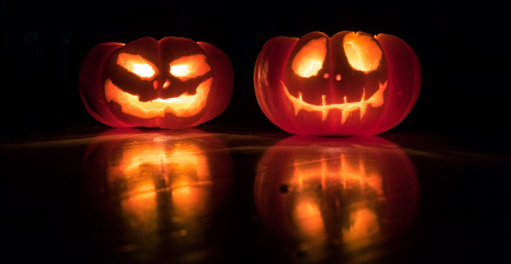 Two lit jack o lanterns. 